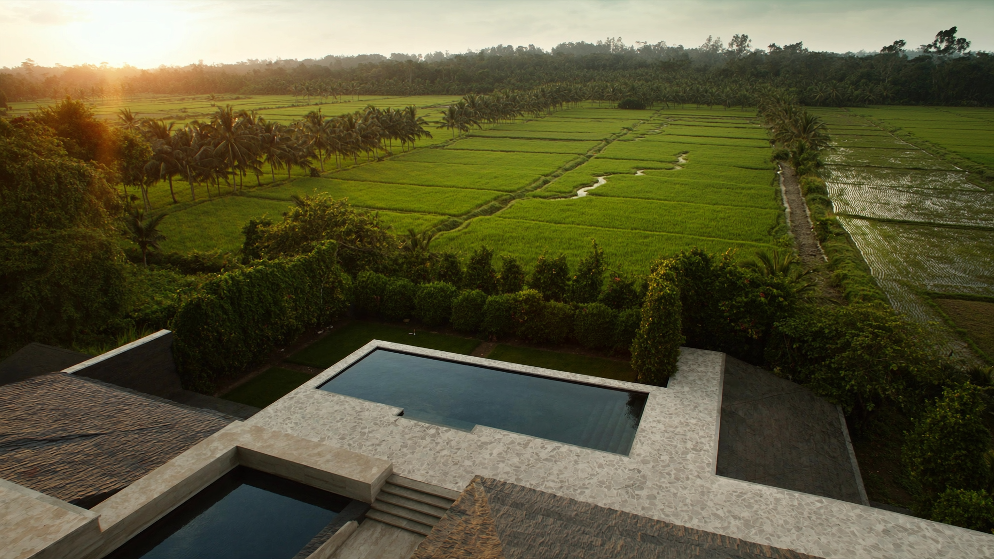 A luxury villa in Canggu Bali overlooking rice terraces at golden hour
